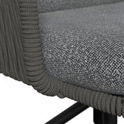 Nahaufnahme eines grauen Armlehnstuhls mit texturierter Polsterung und umwickelten Armlehnen, seitliche Perspektive