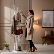 Weiße, freistehende Garderobenständer-Kleiderstange mit Haken, behängt mit Mantel, Schal, Mütze und brauner Tasche in einem modernen Flur; seitliche Ansicht auf das Produkt.