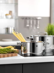 Topfset 5-teilig Passion aus Edelstahl, in moderner Küche auf Herdplatte, mit Spargel und Pasta, seitliche Perspektive