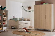 Kinderzimmer-Set mit Kleinkindbett und hohem Kleiderschrank in Beige mit geriffelter Holzoptik, seitliche/frontale Perspektive im Raum