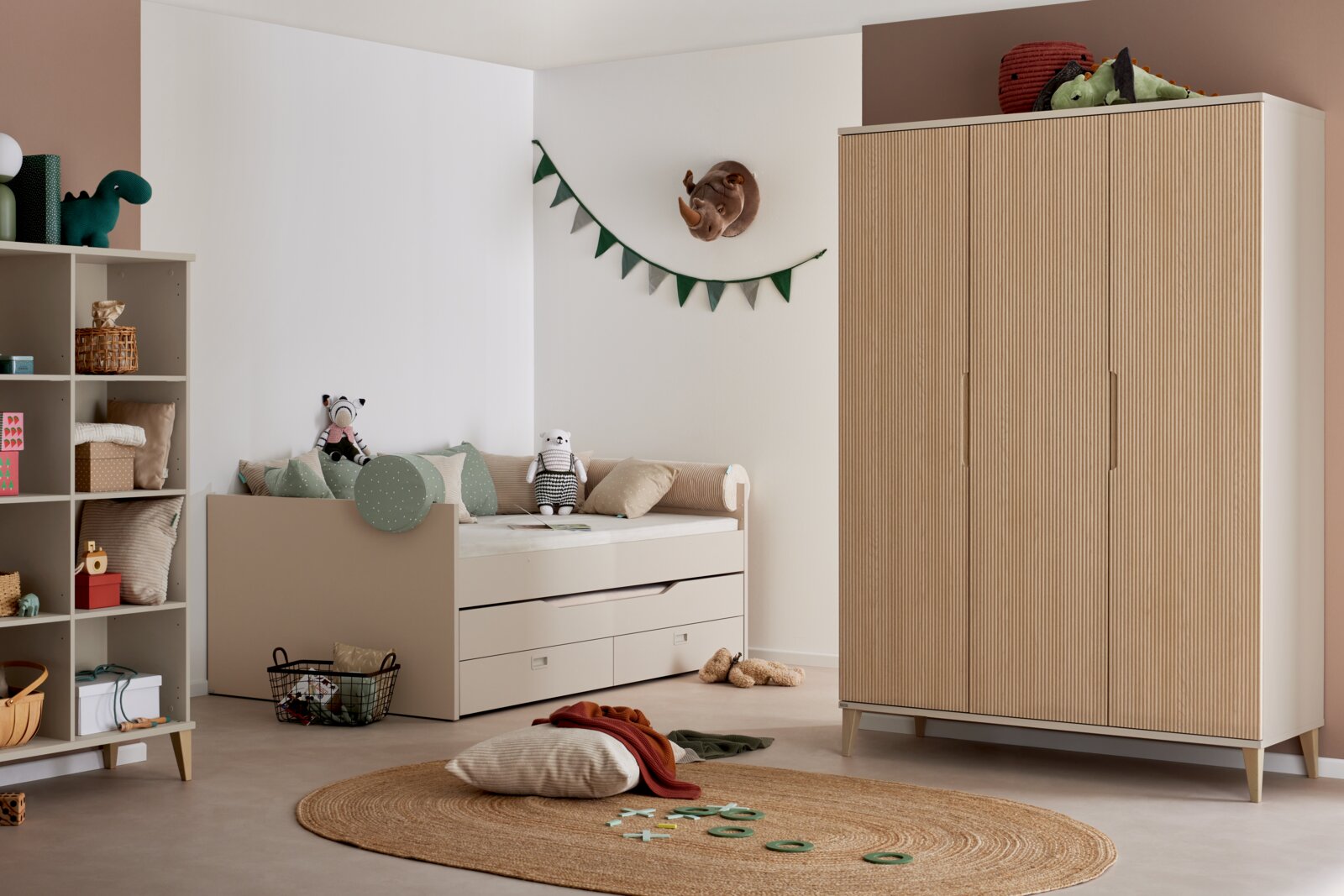 Kinderzimmer-Set mit Kleinkindbett und hohem Kleiderschrank in Beige mit geriffelter Holzoptik, seitliche/frontale Perspektive im Raum