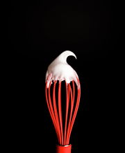 Roter Silikon-Schneebesen mit weißem Schaum, Nahaufnahme von oben