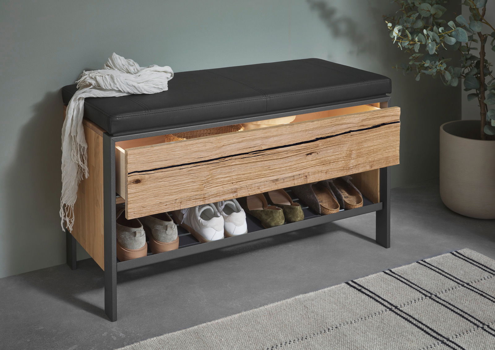 Garderobenbank mit schwarzer Sitzfläche, Holzschublade und Schuhablage, seitliche Perspektive