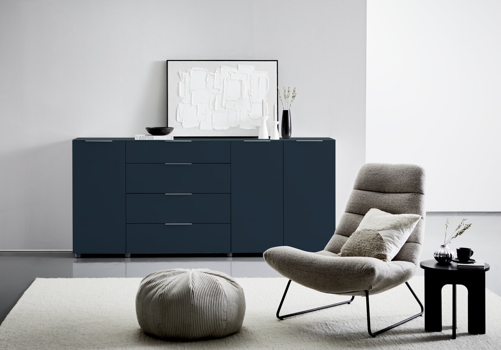 Modernes XL-Sideboard in dunklem Blau mit vier Schubladen und zwei Türen, frontal fotografiert in einem stilvollen Wohnzimmer.