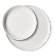 Zwei weiße Teller in Draufsicht, übereinander liegend.