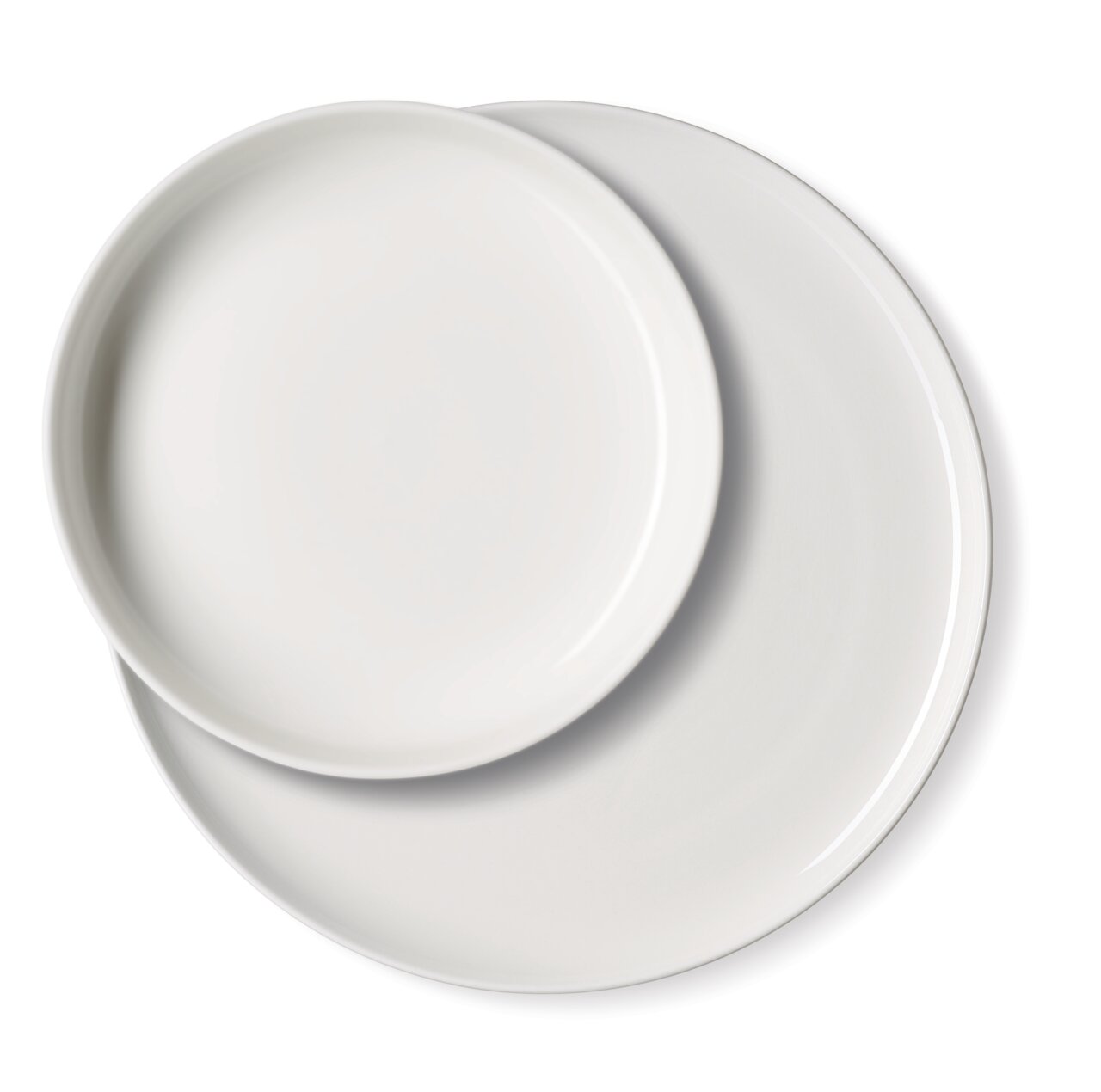 Zwei weiße Teller in Draufsicht, übereinander liegend.