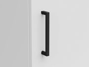 Nahaufnahme eines schwarzen Griffs an einer weißen Schranktür, seitliche Perspektive