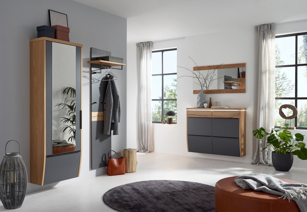 Moderne Garderobeneinrichtung mit hängendem Spiegelgarderobenschrank, Garderobenpaneel und Kommode in Holz- und Grautönen, seitliche Perspektive.