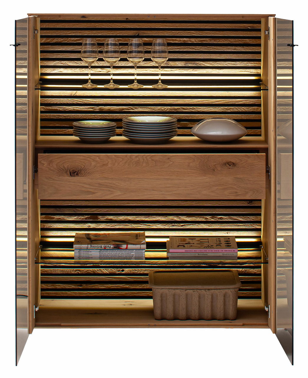 Geöffnetes Highboard aus Holz mit Glastüren, beleuchtetem Innenraum, Gläsern, Tellern und Büchern, frontal betrachtet.