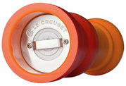 Nahaufnahme der Unterseite einer ofenroten Pfeffermühle mit sichtbarem Mahlwerk und Le Creuset Logo.