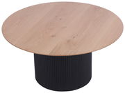 Runder Couchtisch mit heller Holzplatte und schwarzem, geriffeltem Sockel, aus seitlicher Perspektive.