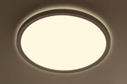 Runde LED-Deckenleuchte aus der Perspektive von unten betrachtet, leuchtend mit warmem Licht.