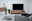 TV-Möbel aus Holz mit Metallakzenten, frontal betrachtet, in einem modernen Wohnzimmer mit grauem Sofa und dekorativen Elementen.