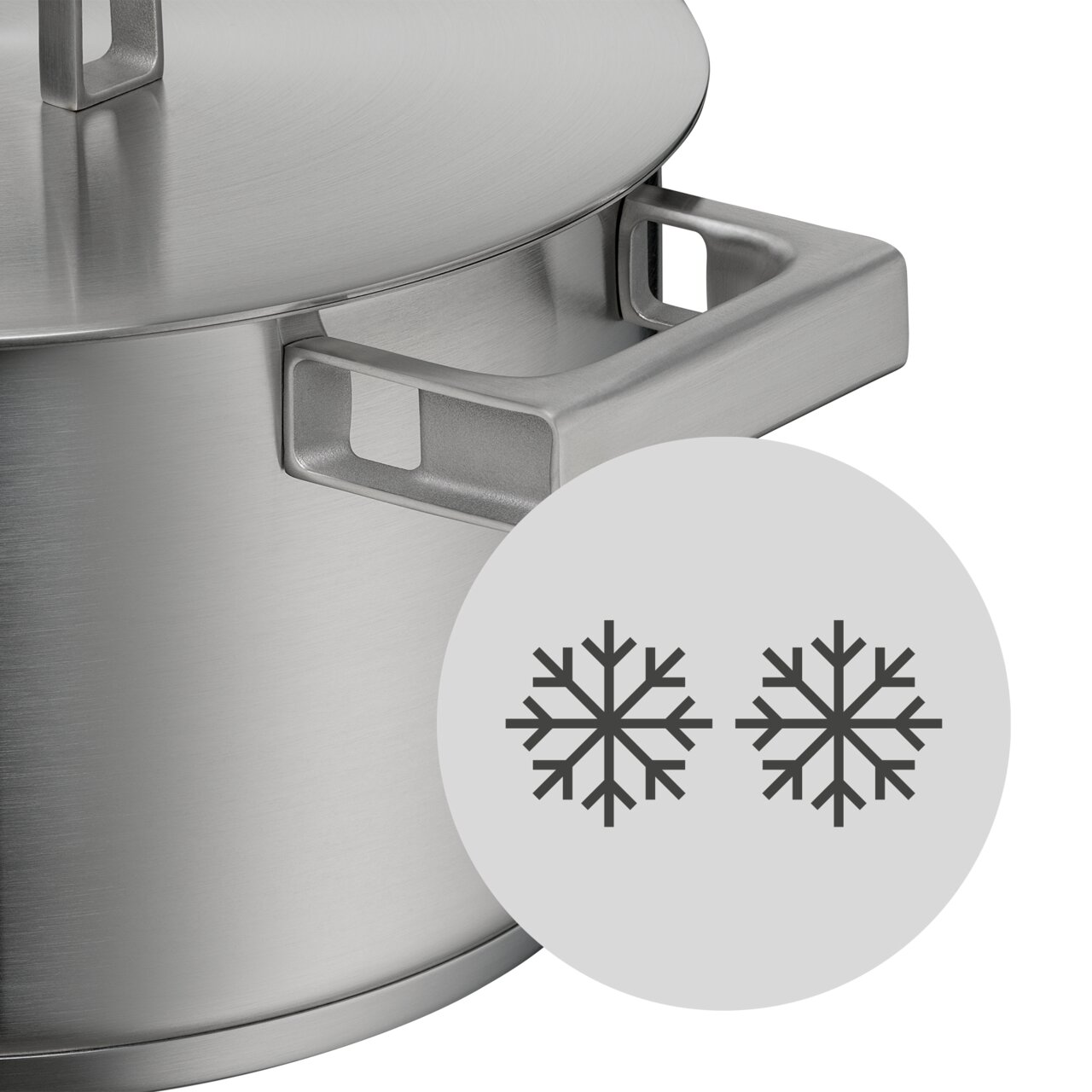 Nahaufnahme eines Topfes aus Edelstahl mit Deckel und Griffen, Teil des WMF Ultimate Cool Topf-Sets, mit einem Symbol für Kühleigenschaften.