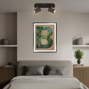 Zweiflammiger LED-Spot in modernem Design, an der Decke über einem stilvoll eingerichteten Schlafzimmer mit einem großen Bild an der Wand. Perspektive von vorne.