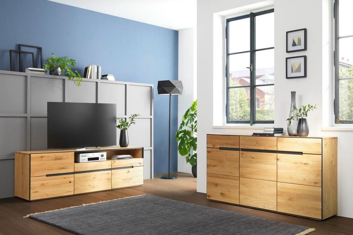 Moderne Wohnzimmermöbel aus Holz, bestehend aus einem TV-Lowboard und einem Sideboard, in einem hellen Raum mit blauen und weißen Wänden, seitliche Perspektive.