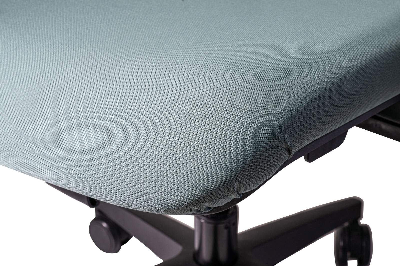 Nahaufnahme eines Bürostuhlsitzes mit hellgrünem Stoffbezug und schwarzem Drehfuß, seitliche Perspektive