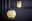Zwei kugelförmige Lampen mit gebürstetem Silberfuß, die warmes gelbes Licht ausstrahlen. Eine Lampe steht im Vordergrund auf einem Tisch, die andere im Hintergrund auf einem Regal.