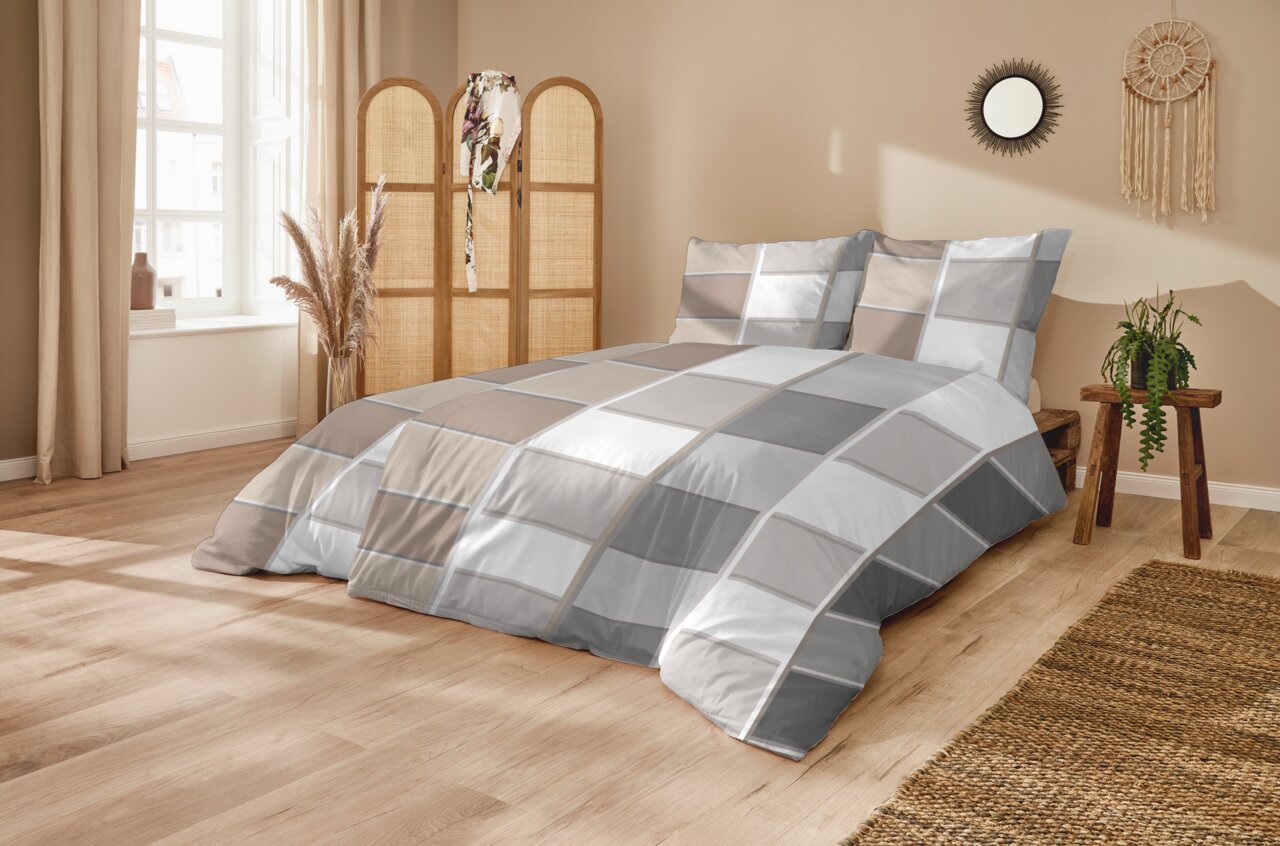 Modernes Schlafzimmer mit Bettwäsche-Set in Grau-, Weiß- und Beigetönen im Karomuster auf einem Doppelbett, fotografiert aus schräger Frontansicht