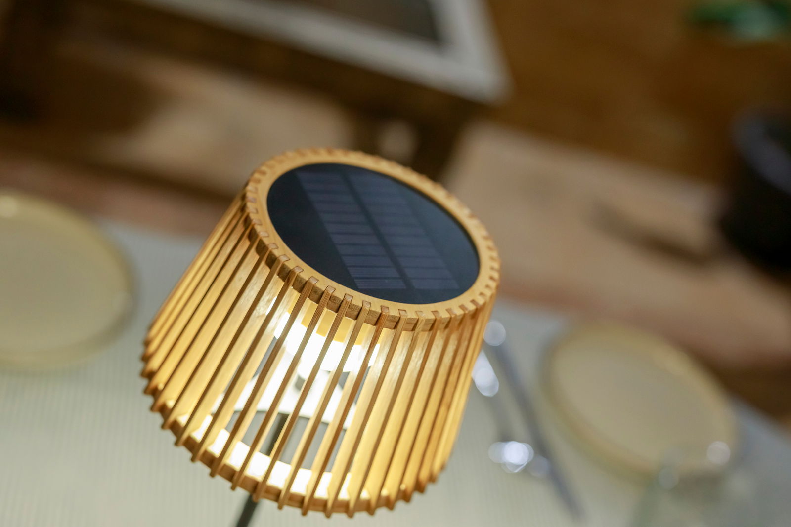 Nahaufnahme einer Solar-Tischleuchte mit Holzlamellen und Solarpanel von oben betrachtet.