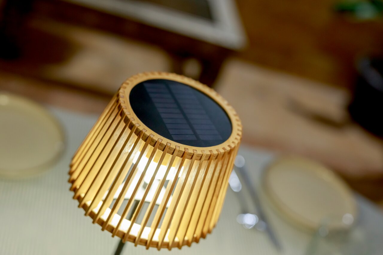 Nahaufnahme einer Solar-Tischleuchte mit Holzlamellen und Solarpanel von oben betrachtet.