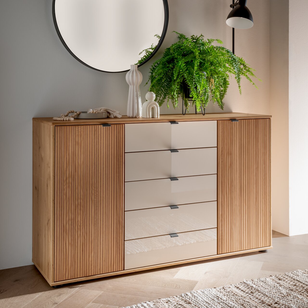 Kombikommode aus Holz mit modernen, glatten Schubladenfronten, dekoriert mit Pflanzen und Accessoires, seitliche Perspektive