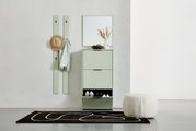 Moderne hal met mintgroene schoenenrek, spiegel en garderobepaneel, van voren gefotografeerd.