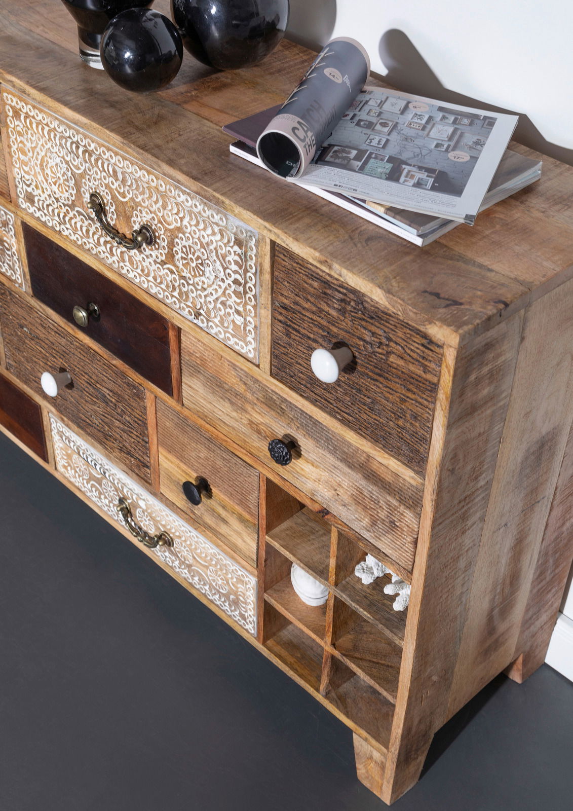 Rustikales Sideboard aus Holz mit verschiedenen Schubladen und dekorativen Elementen, seitliche Perspektive.