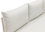 Nahaufnahme einer beigen Gartenlounge mit weichen Kissen, seitliche Perspektive