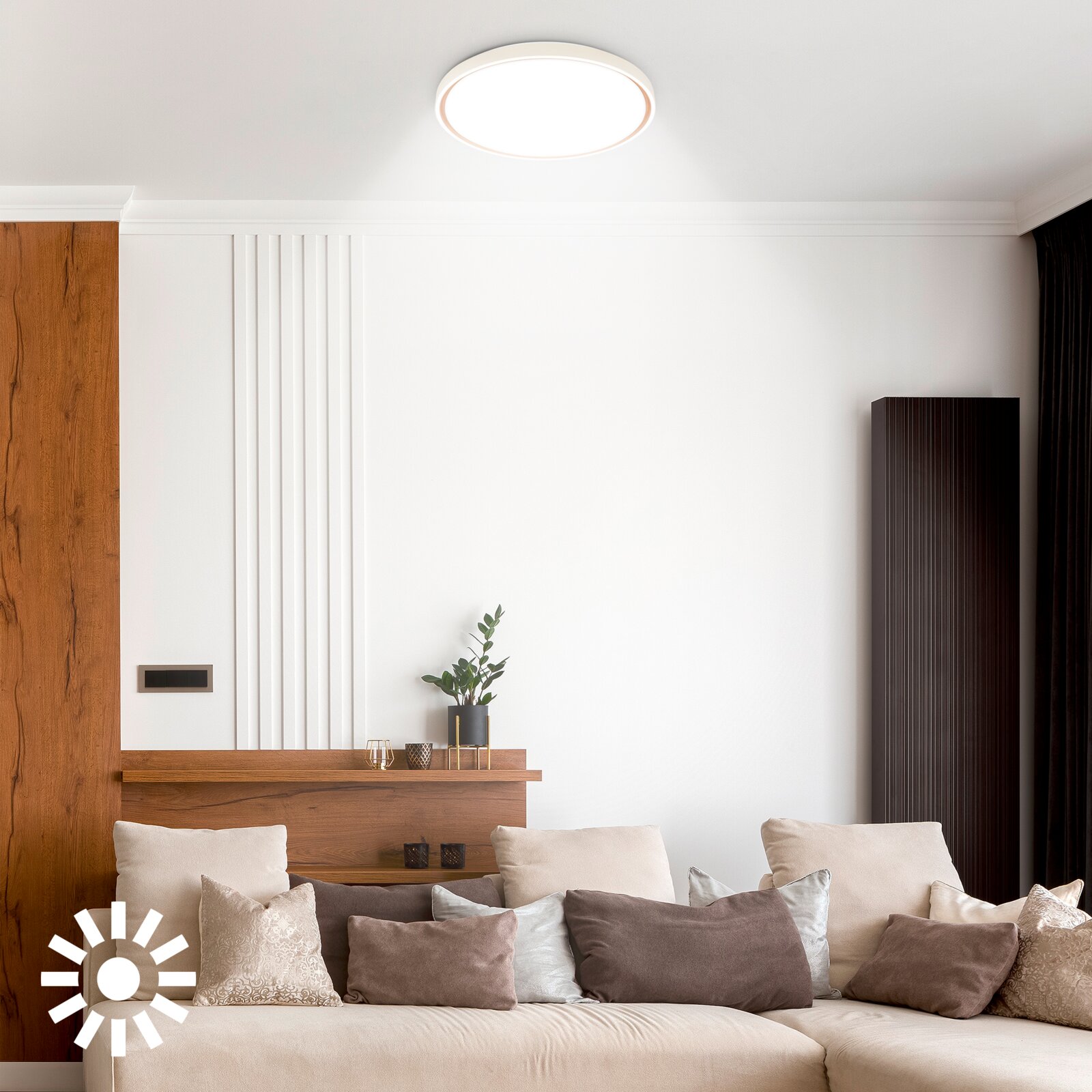 Ronde witte plafondlamp, van schuin onderen gezien, brandend in een modern ingerichte woonkamer