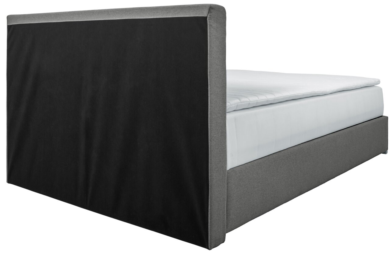 Boxbed 140 in zijaanzicht met grijze stoffen bekleding en een zwart hoofdeinde.
