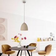 Beige Pendelleuchte mit gesprenkeltem, halbrundem Schirm an langem Kabel über einem Esstisch in modernem Wohnraum, frontale Ansicht in leichtem Untersichtwinkel.