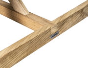 Nahaufnahme eines Holzgestells eines Gartentisches mit Metallplakette, seitliche Perspektive