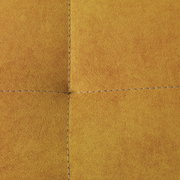 Nahaufnahme einer gelben Stoffoberfläche mit sichtbaren Nähten, perspektivisch von oben betrachtet.