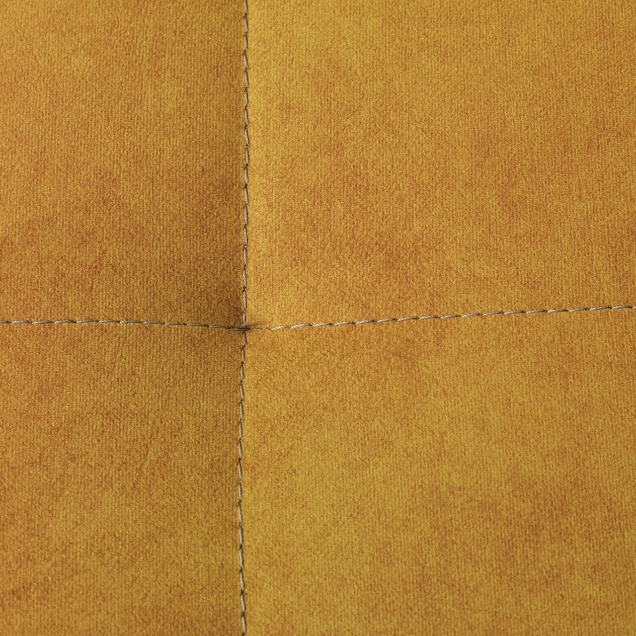 Nahaufnahme einer gelben Stoffoberfläche mit sichtbaren Nähten, perspektivisch von oben betrachtet.