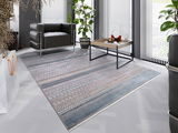 Designer Teppich in modernem Wohnzimmer, Perspektive von oben, mit grauem Sessel, Couchtisch und Pflanzen.