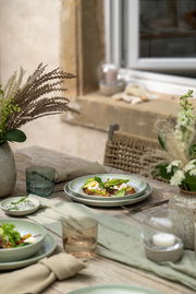 Dipschälchen auf einem gedeckten Tisch im Freien, umgeben von Geschirr und Dekorationen, aus der Vogelperspektive fotografiert.