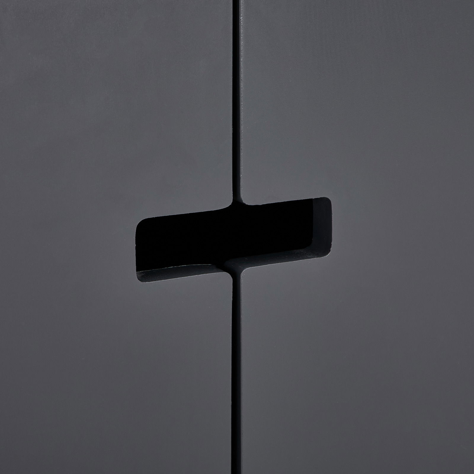 Nahaufnahme eines schwarzen Sideboards mit modernem, minimalistischem Design und einzigartigem Griffdetail.