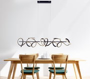 Moderne Pendelleuchte CURLS in geschwungenem Design über einem Esstisch, seitliche Perspektive.