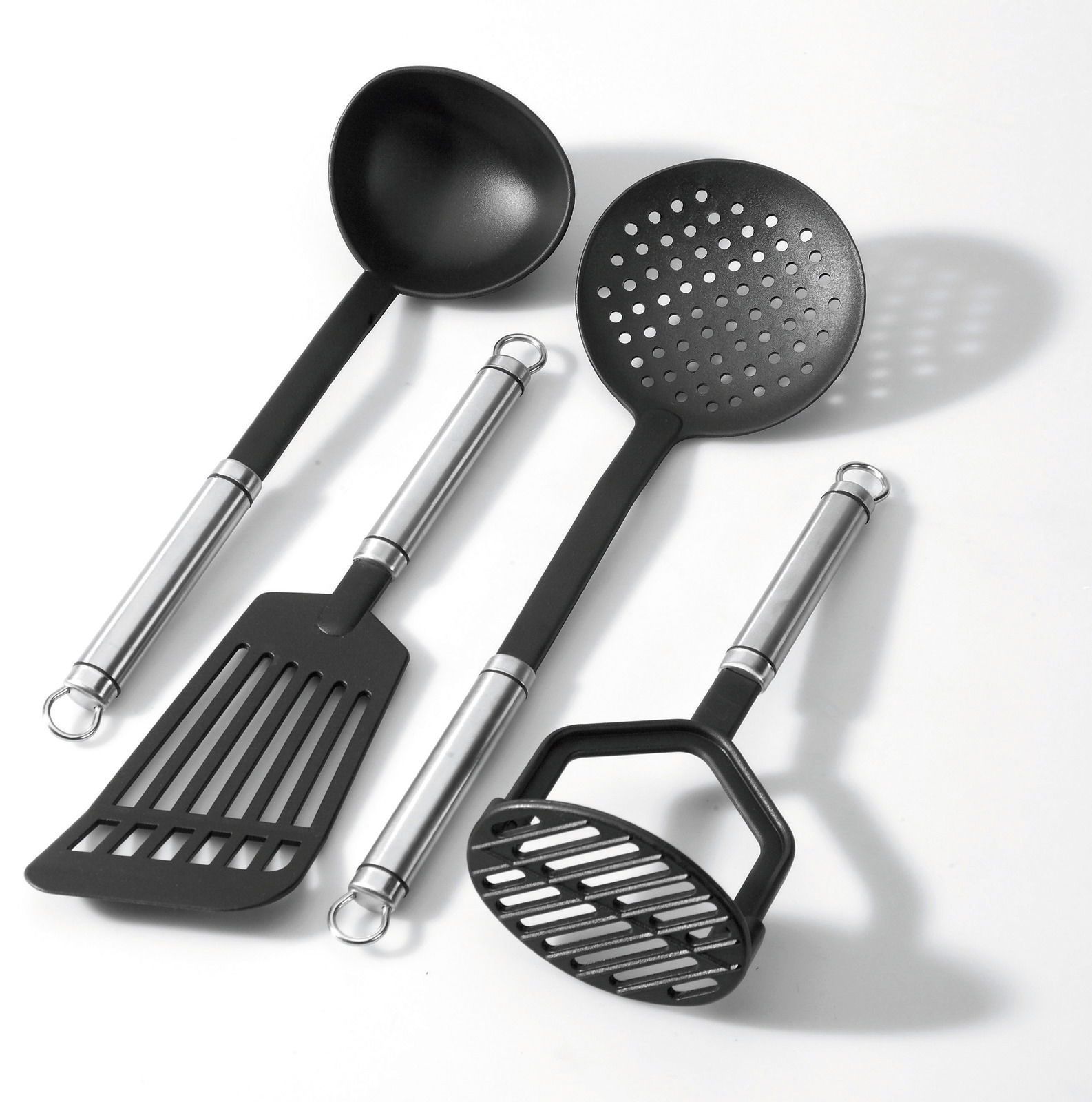 Küchenutensilien-Set bestehend aus einem Suppenschöpfer, einem Schaumlöffel, einem Pfannenwender und einem Kartoffelstampfer, aus schwarzem Nylon mit Edelstahlgriffen, aus der Vogelperspektive fotografiert.