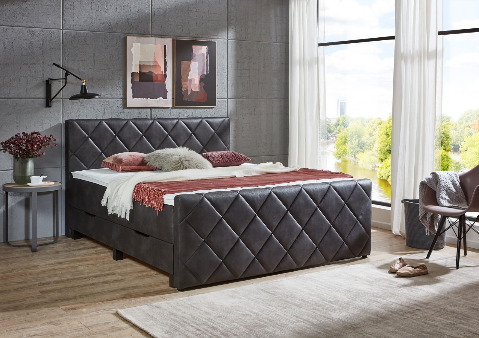 Boxbett mit gestepptem Kopf- und Fußteil in einem modernen Schlafzimmer, seitliche Perspektive