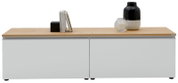 Modernes Sideboard mit weiß-grauen Fronten und heller Holzplatte, dekoriert mit Büchern und schwarzer Vase, frontal aus leicht erhöhter Perspektive aufgenommen