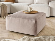 Hocker in Nahaufnahme, beige gestreifter Stoff, mit Tablett und Tasse darauf, auf Holzfußboden vor einem Sofa.
