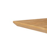 Nahaufnahme einer Tischkante aus Holz, perspektivisch von der Seite aufgenommen.