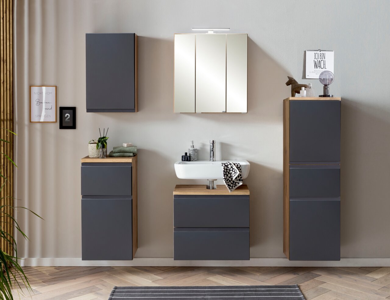 Moderner Hängeschrank in dunklem Grau mit Holzdetails, frontal im Badezimmer montiert.