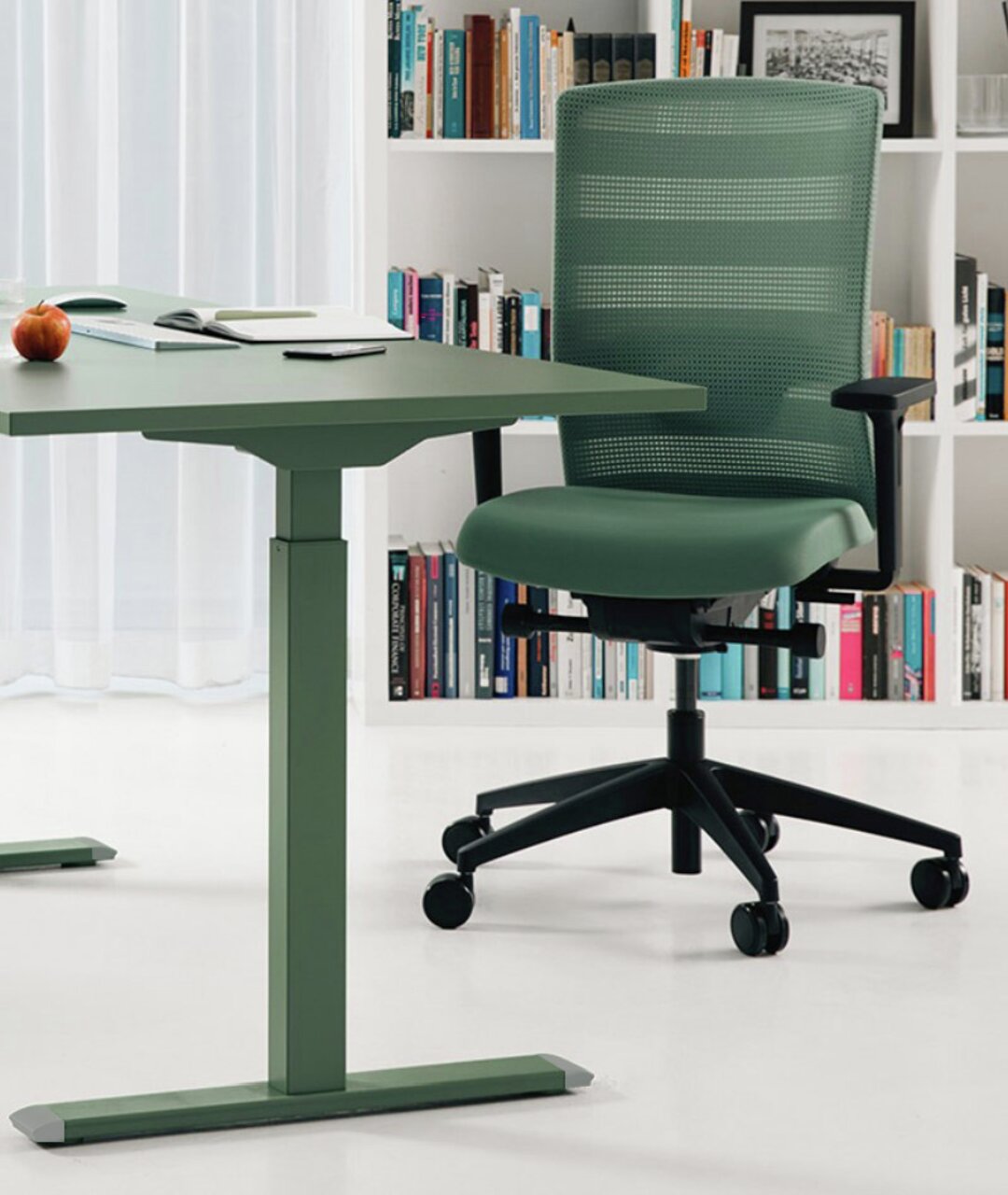 Topstar E-Schreibtisch E-TABLE COLOR Moderner grüner E-Schreibtisch und Bürostuhl in einem stilvollen Raum mit Bücherregal im Hintergrund, seitliche Perspektive.
