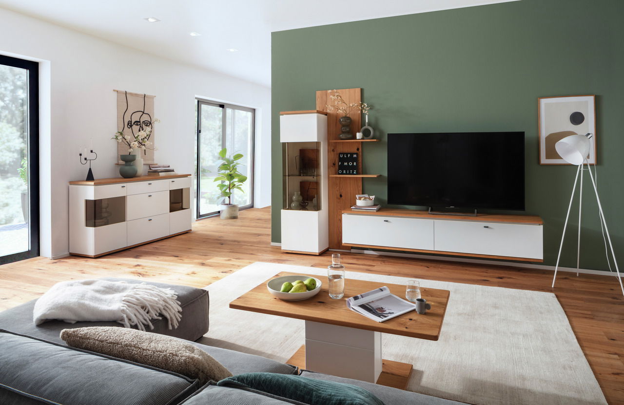 Novel Sideboard MATADI Modernes Sideboard im Wohnzimmer, Perspektive von der Seite, mit weißem Korpus und Holzoberfläche, dekoriert mit Vasen und Büchern.