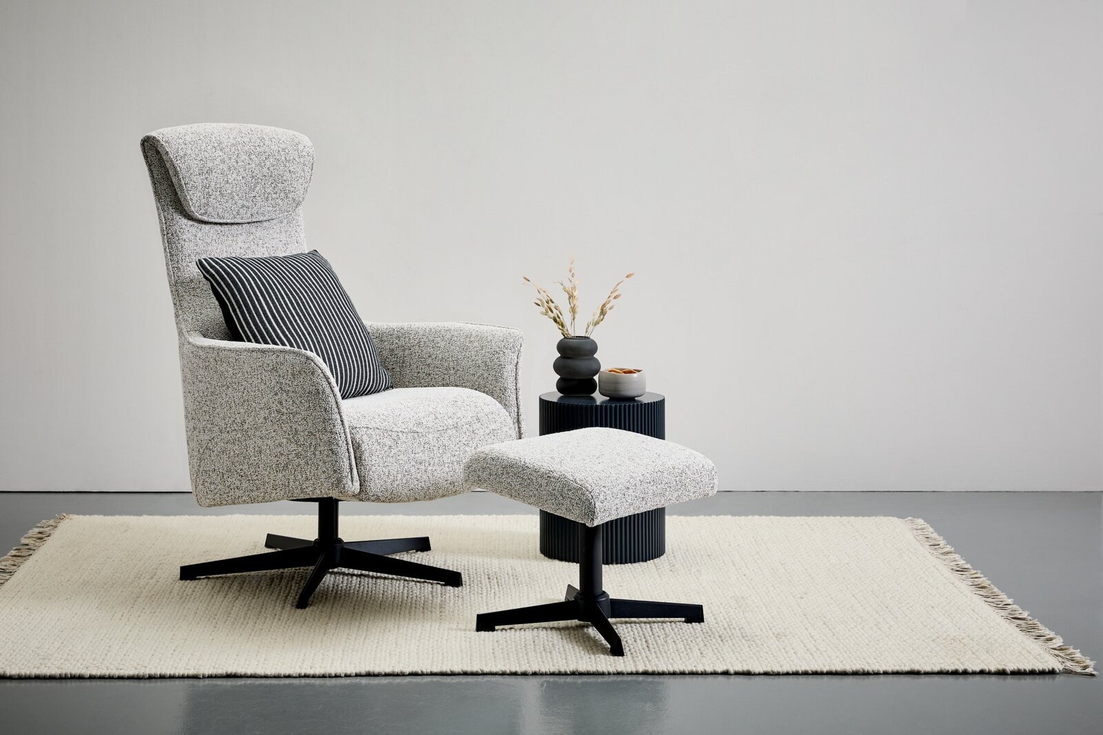 Welnova Relaxsessel mit Hocker VICTORIA Seitenansicht eines modernen Relaxsessels mit Hocker auf einem Teppich, begleitet von einem kleinen Beistelltisch mit Dekoration.
