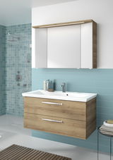 Moderner Badblock mit Holzoptik und weißem Waschbecken, frontal betrachtet, vor einer türkisfarbenen Fliesenwand.