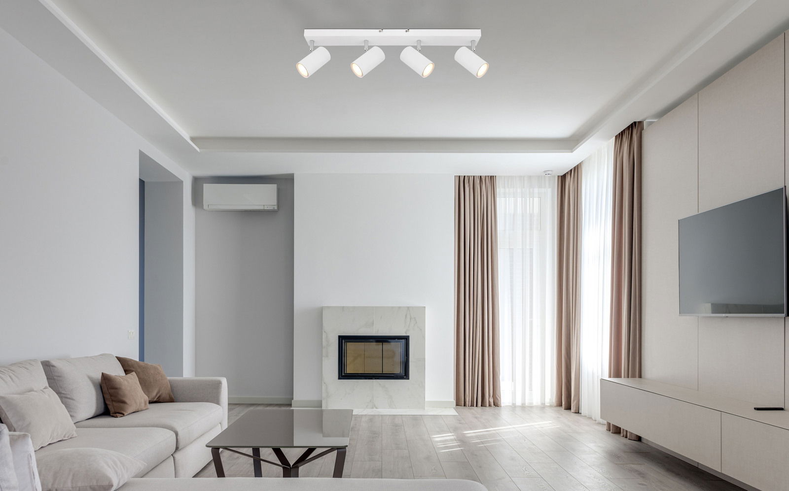 Moderner weißer Deckenstrahler mit vier verstellbaren Spots in einem stilvollen Wohnzimmer, Perspektive von unten.